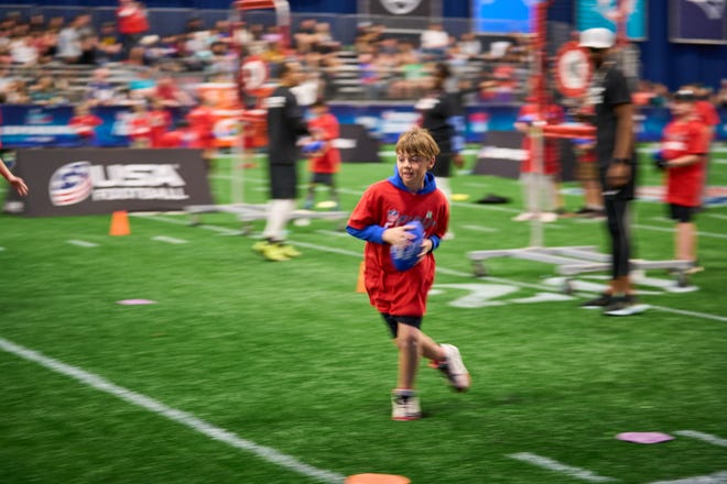 Young football fans participate in the NFL Play 60 event during the Super Bowl Experience at the Phoenix Convention Center on Feb. 5, 2023.