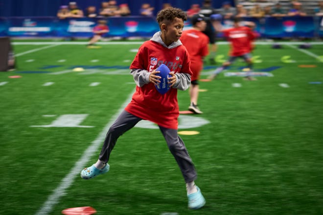 Young football fans participate in the NFL Play 60 event during the Super Bowl Experience at the Phoenix Convention Center on Feb. 5, 2023.